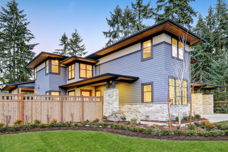 Luxurious new construction home in Bellevue, WA. Modern style home boasts two car garage framed by blue siding and natural stone wall trim. Northwest, USA